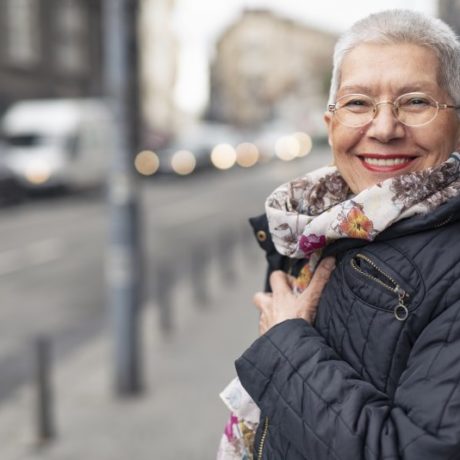 an older woman smiling while bundled up in a coat
